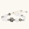 Adjustable beaded bracelet with spotted dalmatian stones, clear quartz crystals, and silver star charm on white background.